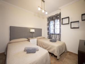 ein Schlafzimmer mit zwei Betten und einem Fenster in der Unterkunft Playa Verde PLUS by Ĥ - Playa Punta del Moral PPHV58P39 in Punta del moral + 18 Fotos