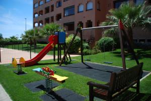 einen Spielplatz mit Rutsche und Schaukel in der Unterkunft Playa Verde PLUS by Ĥ - Playa Punta del Moral PPHV58P39 in Punta del moral