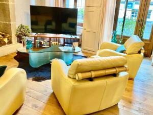 ミュラにあるHôtel Restaurant du Plomb du Cantalのリビングルーム(黄色い椅子、テレビ付)