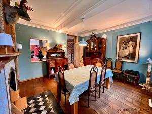 una sala da pranzo con tavolo e sedie di La maison de Maître - Grand Jardin, Face à la Meuse a Hermalle-sous-Argenteau