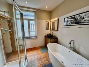 un bagno con vasca e doccia di La maison de Maître - Grand Jardin, Face à la Meuse a Hermalle-sous-Argenteau