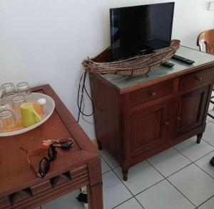 圣安娜Studio avec kitchenette à deux pas de la mer的梳妆台上方的电视,配有桌子