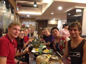 a group of people sitting at a table eating food at Rainbow Lodge HK in Hong Kong