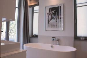 a white bathroom with a tub and a sink at Bluepearl, Villa Charlotte in Binz +13 photos