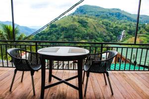 a table and two chairs on a balcony with a view at Nature Rock Ella in Ella