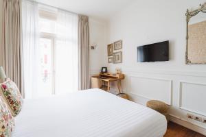a bedroom with a bed and a tv on a wall at Hotel Edouard VII in Biarritz