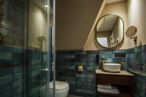 ein Badezimmer mit Toilette, Waschbecken und Spiegel in der Unterkunft Hotel Ratsmühle Lüneburg in Lüneburg
