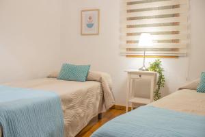 una habitación con dos camas y una mesa con lámpara en Vivienda Vacacional Finca La Redonda El Paso, en El Paso