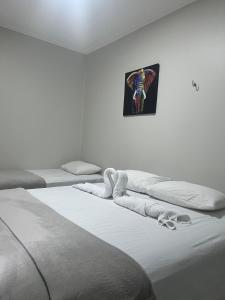 a room with two beds and a picture on the wall at STILLO AÇAI in Bragança +10 photos