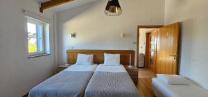 una camera da letto con due letti e una finestra di Quinta da Bornacha - Casa A a Vila Nova de Cacela Altre 28 foto
