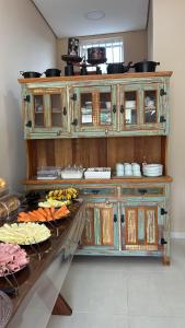 a large wooden cabinet with food on a table at Pousada Beata Francisca de Paula in Aparecida