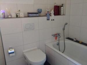 Un baño blanco con inodoro y bañera. en Gorgeous Chalet in Truttli Area of Lauenen, en Lauenen 19 fotos más