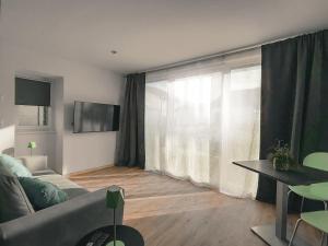a living room with a couch and a table and a window at La Clef des Franches in Saignelégier