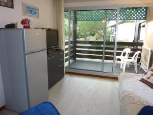 a living room with a refrigerator and a balcony at LE COURANT D'HUCHET in Moliets-et-Maa