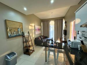 a living room with a table and a couch at Infinity - Stunning 1 bedroom apartment with sea & mountain views in Bloubergstrand