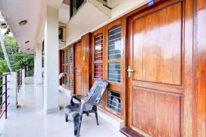 a room with wooden doors and a chair on a porch at Mattuppavu Beach House in Vilinjam +12 photos