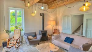 a living room with a couch and a wood stove at La Casa Do - Havre de Paix au Bord de L'eau in Cuisery
