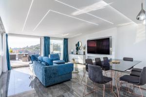 a living room with a blue couch and a table at Luxury Penthouse Sea View with terrace in Giardini Naxos