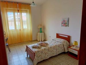 a bedroom with a bed and a table with a lamp at Mariangela's Home in Carbonia