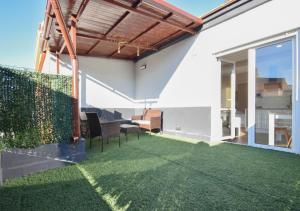 een patio met een grasvloer en een tafel en stoelen bij Home4u San Ambrosio in Granada