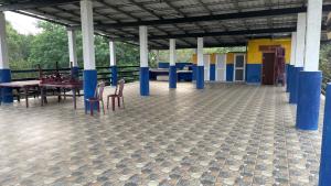 a pavilion with tables and chairs on a tiled floor at Saa in Anuradhapura