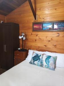 a bedroom with a bed with a wooden wall at Tiny House Novas Palmeiras in Florianópolis