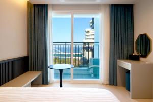 江陵市Hotel Sollavue的一间带床的卧室和一扇可欣赏风景的窗户