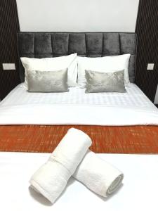 un letto con testiera nera e cuscini bianchi di R&F Princess Cove, Seine Region 2Bedroom with Balcony by 9 Sands a Johor Bahru Altre 59 foto