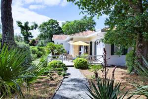 a white house with a garden and a patio at Villa Surprise in Arcachon