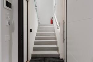 a hallway with stairs with a red fire extinguisher at Residence i Tigli in Cinisello Balsamo