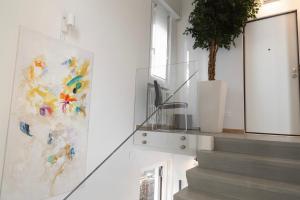 a staircase with a painting and a potted plant at Residence i Tigli in Cinisello Balsamo