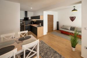 a kitchen and living room with a table and a couch at Apartmány Pod náměstím 2 in Telč