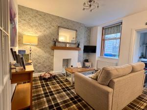 a living room with a couch and a fireplace at The Stags Head Apartment in Inverness