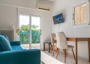 a living room with a table and a blue couch at Secret Oasis Aptms Room 2 in Larisa