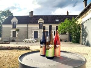 drei Flaschen Wein auf dem Tisch in der Unterkunft Villa coco 9 personnes jardin proche Beauval in La Vernelle