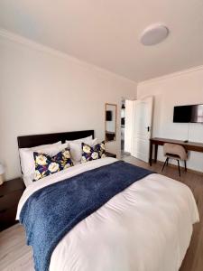 a bedroom with a large white bed and a desk at 2nd on Strand in Cape Town