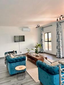 a living room with a blue couch and a table at 2nd on Strand in Cape Town