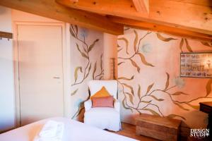a bedroom with a wall with a painting of leaves at GRABBIA 12 by Design Studio in Bellano