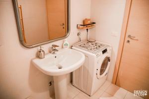 a bathroom with a sink and a washing machine at GRABBIA 12 by Design Studio in Bellano +36 photos