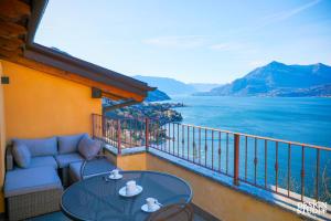 a balcony with a couch and a table with a view of the water at GRABBIA 12 by Design Studio in Bellano