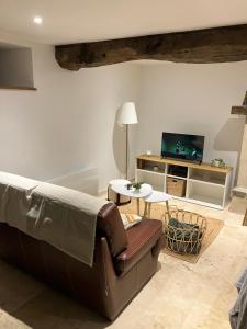 a living room with a couch and a table at Le Dervillé in Roz-sur-Couesnon