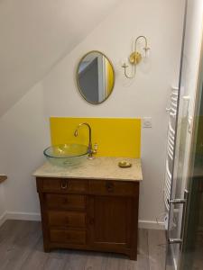a bathroom with a glass sink and a mirror at Le Dervillé in Roz-sur-Couesnon