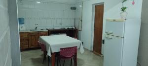 a kitchen with a white table and a refrigerator at Dulce Sol Hospedaje in Gualeguaychú