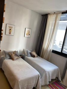 a bedroom with two beds and a window at Tuc540 in Buenos Aires