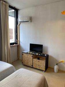 a room with two beds and a dresser with a television at Tuc540 in Buenos Aires