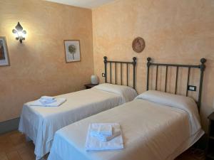 two beds in a hotel room with towels on them at Appartamento Il Cantico Del Gallo, Wifi, Near Perugia in Colle +19 photos