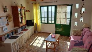 ein Wohnzimmer mit einem Sofa und einer grünen Tür in der Unterkunft Inviting 1-bedroom house 'Esquina' Finca Vistamar in Salobre