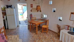 eine Küche mit Holztisch und Kühlschrank in der Unterkunft Inviting 1-bedroom house 'Esquina' Finca Vistamar in Salobre