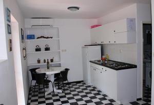 a kitchen with a sink and a table with chairs at Rab From Above Studio Apartment in Rab