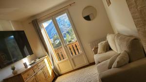 un salon avec un canapé et une grande fenêtre dans l'établissement Cosy appart à la montagne, à Seyne